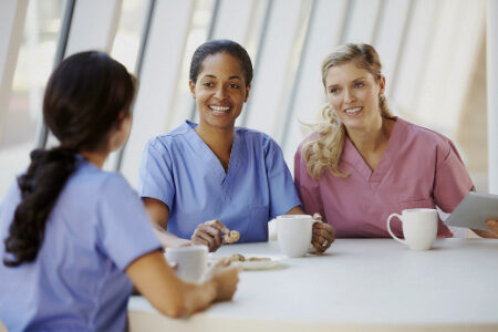 Three nurses enjoying coffee in a hospital cafeteria