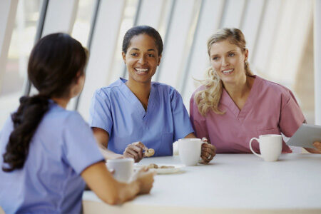 Three nurses enjoying coffee in a hospital cafeteria